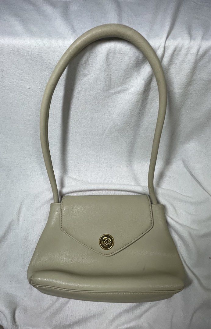 Cream Envelope Shoulder Bag with Gold Clasp (Category: Luxury Bags & Wallets) located in Mandaluyong City. Submitted by coolmeybab (Listing ID 1461822383, Image 1). Description: - Elegant cream-colored shoulder bag - Stylish envelope flap with a secure gold clasp closure - Comfortable single curved handle - Interior includes a zippered pocket and a small slip pocket for organization - Clean and well-maintained lining.
