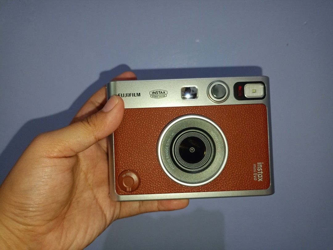 Fujifilm Instax Mini Evo Hybrid Instant Camera with Case (Category: Cameras) located in Manila. Submitted by cutebunny_17 (Listing ID 1461852299, Image 2). Description: - Fujifilm Instax Mini Evo hybrid camera - Comes with a stylish brown leather case - Includes a convenient strap - Pack of 10s Instax Mini film included - with tempered glass on screen - Perfect for capturing and printing memories instantly - Just 1 month old, used twice or thrice