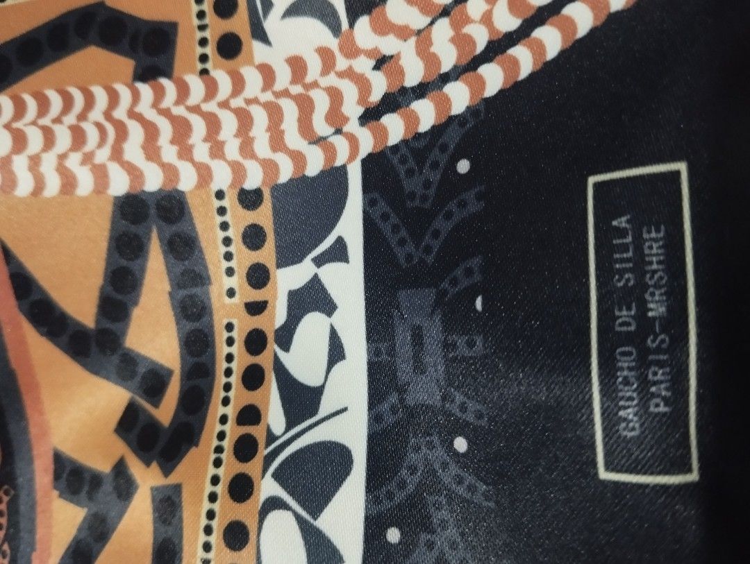 Gaucho de Silla Paris-Mrshire Drawstring Bag (Category: Cross-body Bags) located in Manila. Submitted by beckylafea (Listing ID 1461855124, Image 3). Description: - Eye-catching drawstring bag - Colorful scarf-like print on one side - Classic black and white paisley print on the other side - Elegant silver chain strap - Ideal for carrying daily essentials - Dimensions: Approximately 10 inches tall and 8 inches wide.