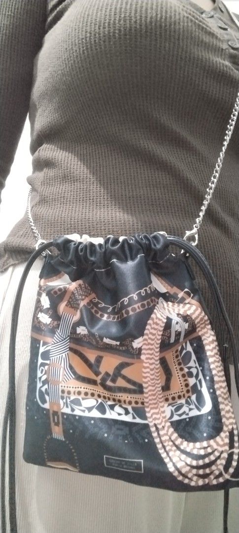 Gaucho de Silla Paris-Mrshire Drawstring Bag (Category: Cross-body Bags) located in Manila. Submitted by beckylafea (Listing ID 1461855124, Image 1). Description: - Eye-catching drawstring bag - Colorful scarf-like print on one side - Classic black and white paisley print on the other side - Elegant silver chain strap - Ideal for carrying daily essentials - Dimensions: Approximately 10 inches tall and 8 inches wide.
