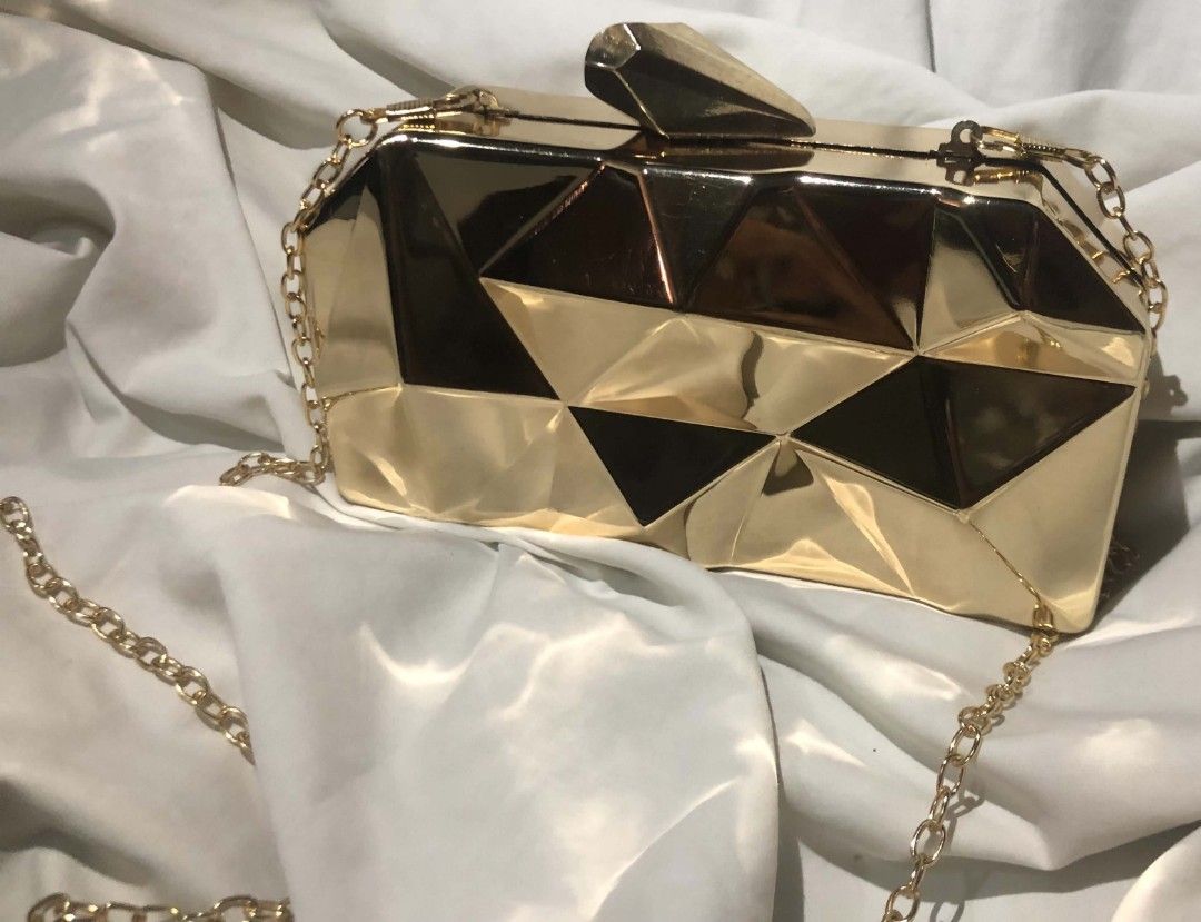 Gold cluth with Geometric pattern (Category: Clutches) located in Manila. Submitted by nabi_shesellsnotseashells (Listing ID 1461948257, Image 2). Description: • Good condition • No issues or damages • Comes with a gold chain strap • Perfect for events, or special occasions • Pre-loved, but still in great shape 🤍 📌 Selling because: Decluttering 💰 Price: ₱800 (can be negotiated) + shipping fee.