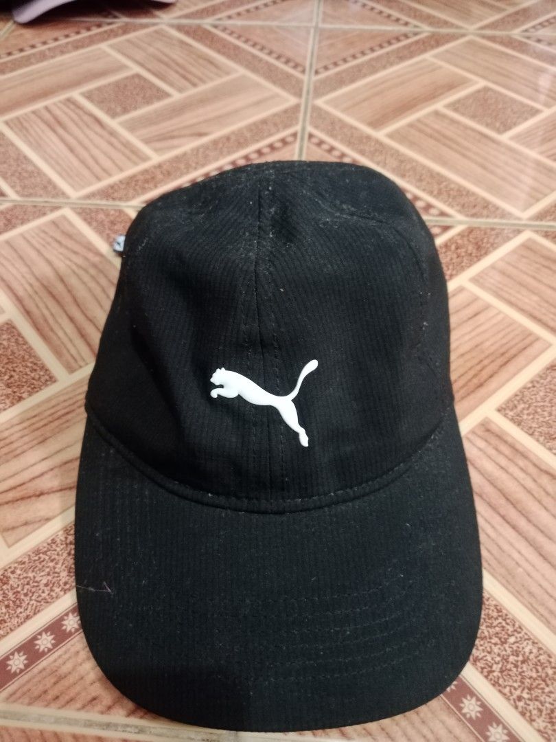 Gorra Puma Essentials, MX (Category: Caps & Hats) located in Naga. Submitted by thrift.vincent (Listing ID 1461849868, Image 1). Description: Puma Essentials baseball cap in black with white embroidered Puma cat logo on the front. 89% polyester, 11% spandex. Adjustable strap with Puma branding at the back. Style No: PV7-0752. Hand wash only. Pre-owned with no visible wear. Clean inside and out.