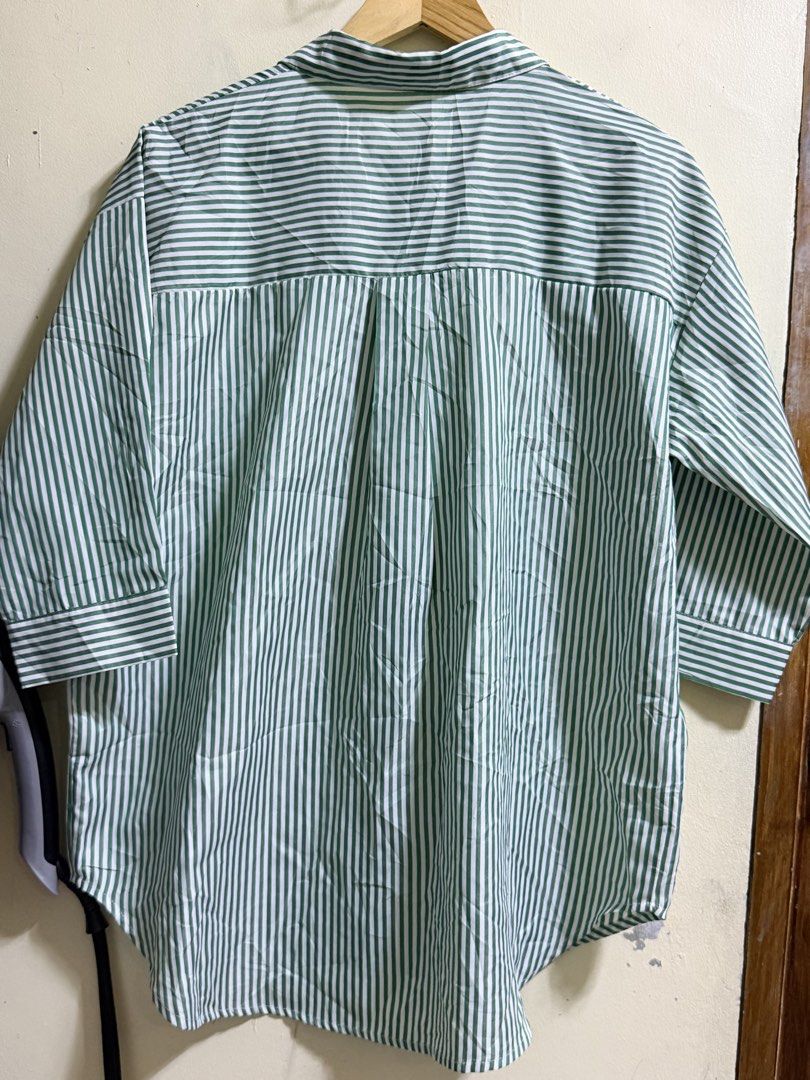 Green and White Striped Button-Up Shirt (Category: Shirts) located in Paete. Submitted by skydruemadison (Listing ID 1461922152, Image 2). Description: - Classic green and white striped button-up shirt - Collared neckline with front button closure - Three-quarter length sleeves with button cuffs - Lightweight and breathable fabric - Versatile for casual or semi-formal occasions - Pairs well with jeans or trousers.