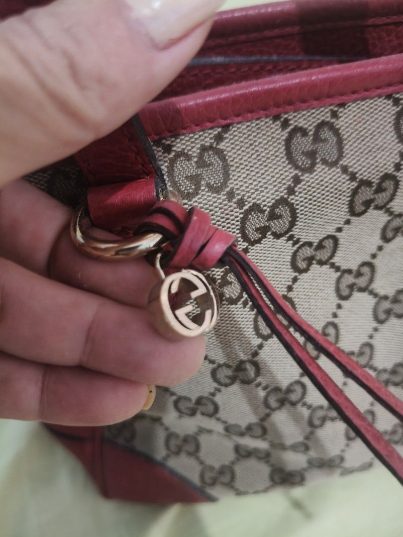 Gucci Monogram Canvas and Leather Handbag (Category: Luxury Bags & Wallets) located in Bulacan. Submitted by aichang21 (Listing ID 1461838741, Image 2). Description: - Authentic Gucci handbag - Classic GG monogram canvas - Red leather trim and handles - Small Gucci charm detail - Zipper closure - Interior tag: 'Gucci Made in Italy' - Ideal for everyday use.