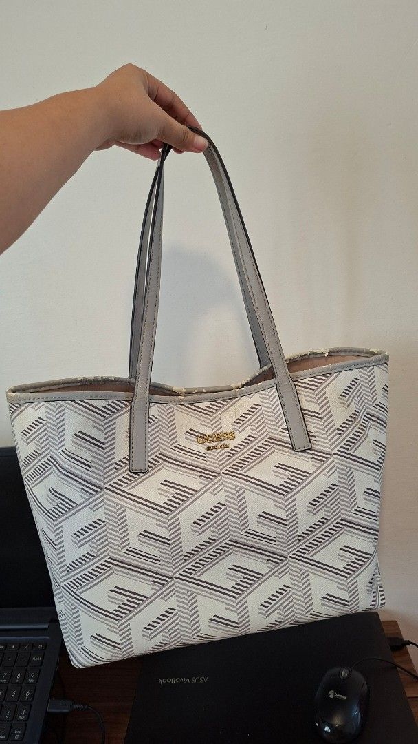 Guess Monogram Tote Bag (Category: Tote Bags) located in Cavite. Submitted by trishadvb (Listing ID 1461823611, Image 2). Description: 📍 General Trias, Cavite - Original Guess tote bag (Vikky Tote Bag) - Bought for 5k - Chipping parts due to storage (see images) - Features a geometric monogram pattern - Grey trim and handles - Clean interior lined with Guess logo - Solid grey base - Ample space for essentials - Ideal for everyday use.