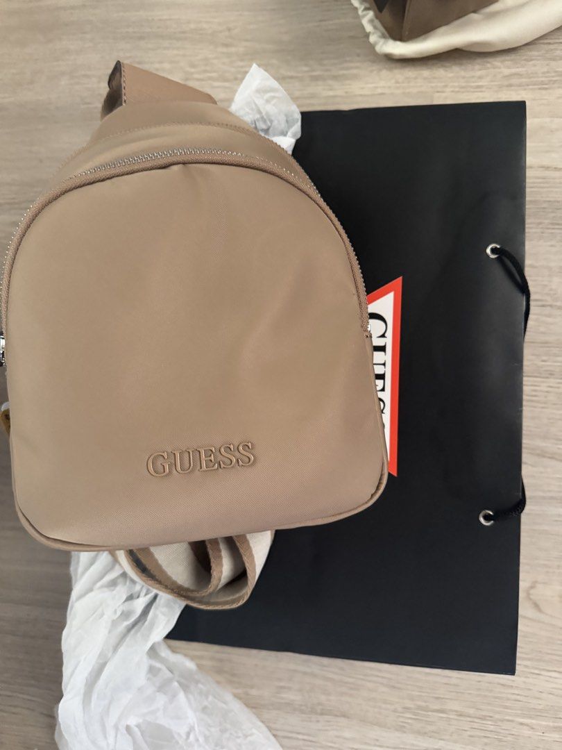 Guess Sling Bag (Category: Cross-body Bags) located in Paranaque City. Submitted by cleverturtle.391c7c (Listing ID 1461807452, Image 1). Description: - Tan colored Guess sling bag - Features embossed Guess logo on the front - Comes with a black Guess shopping bag - Ideal for everyday use.