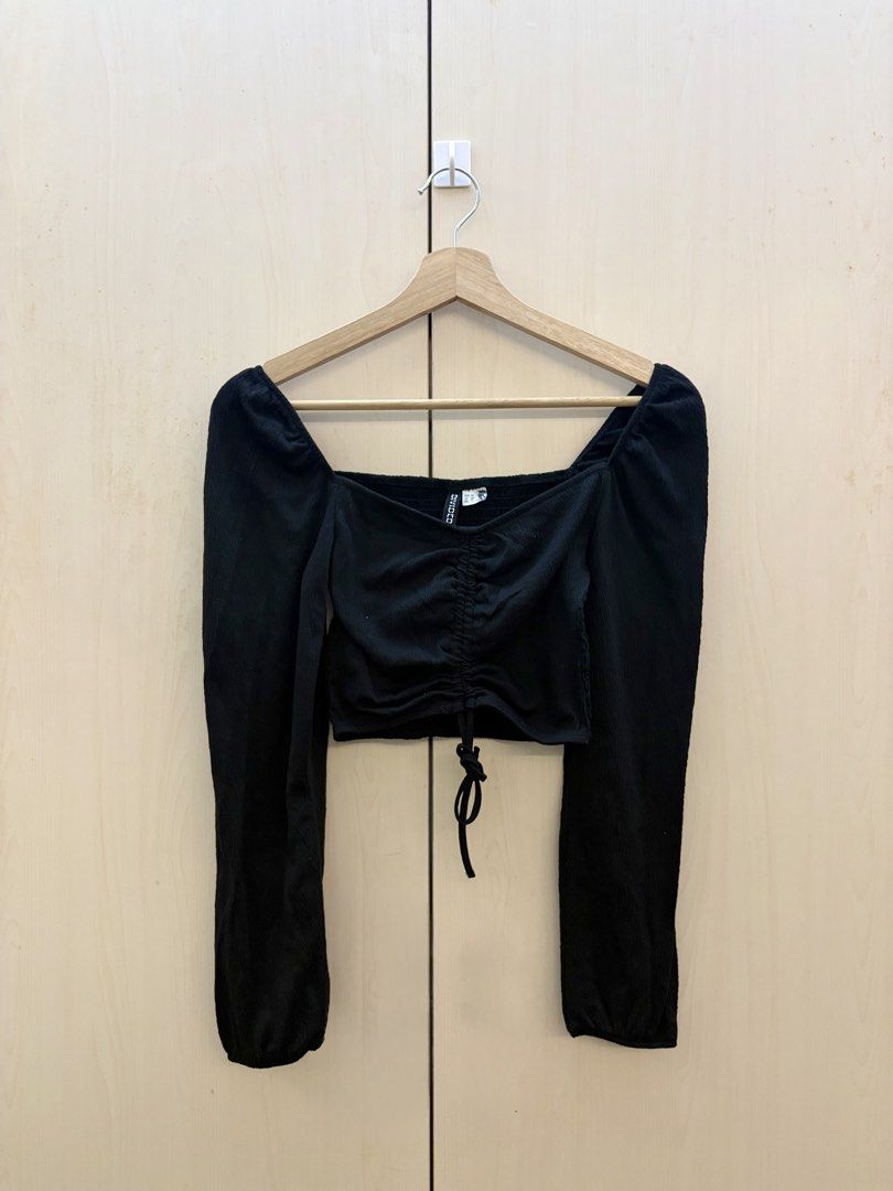 H&M Black Ruched Long Sleeve Crop Top (Category: Others Tops) located in Manila. Submitted by amityclutter (Listing ID 1461945457, Image 1). Description: - Black long sleeve crop top - Brand: H&M Divided - Features a square neckline - Ruched detailing in the front with a drawstring - Puff sleeves for a stylish touch - Perfect for dressing up or down - Pairs well with high-waisted bottoms.
