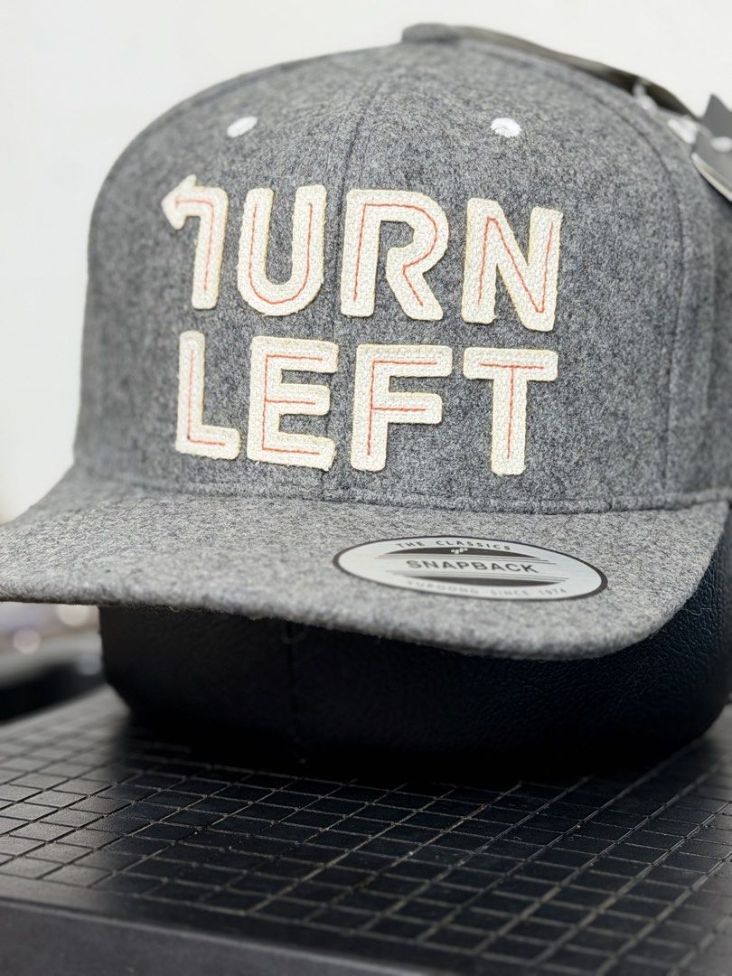 HYPHEN Snapback Hat - Turn Left Grey Wool Blend (Category: Caps & Hats) located in Manila. Submitted by bunsmayo31 (Listing ID 1461992761, Image 1). Description: - Grey snapback hat - 'TURN LEFT' embroidered on the front - Wool blend feel - Adjustable snap closure at the back - Small arrow detail on the back - Brand new with original tags attached.