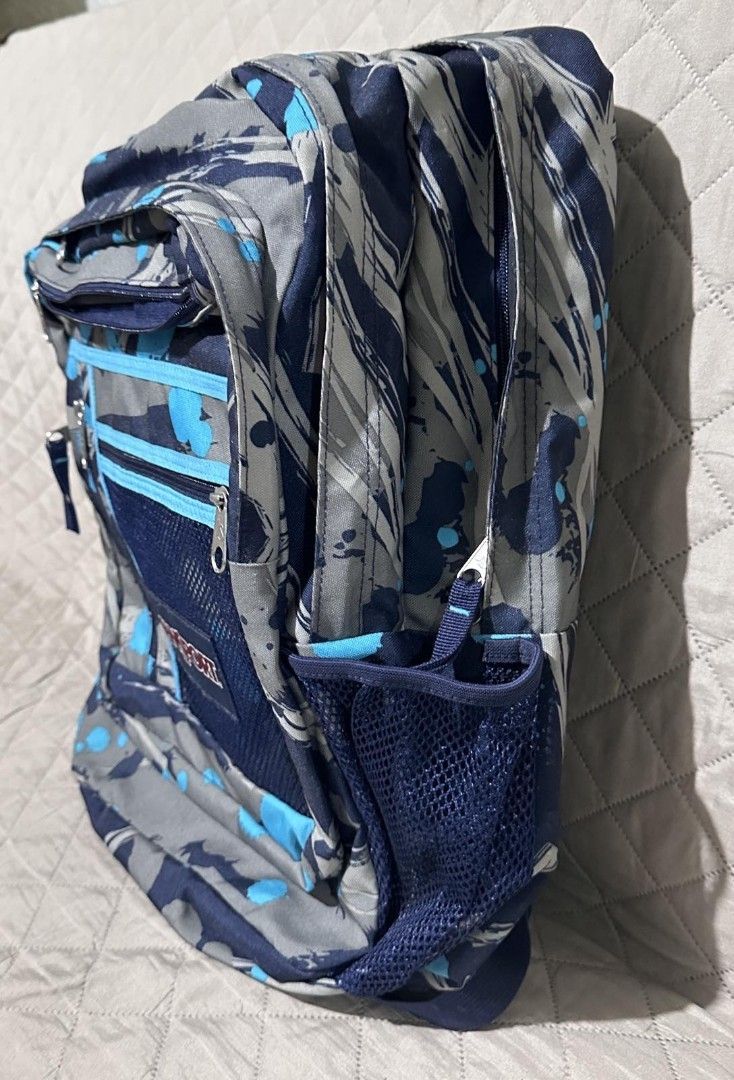 Jansport Backpack - Splatter Paint Design (Category: Backpacks) located in Imus. Submitted by snapandsketch (Listing ID 1461826980, Image 1). Description: - - Stylish backpack with unique blue, grey and black splatter design - Carrying capacity : 26 liters - With multiple compartments and pockets for organized storage - Convenient mesh side pockets for water bottles or quick access items - Padded shoulder straps to ensure comfortable carrying, ev