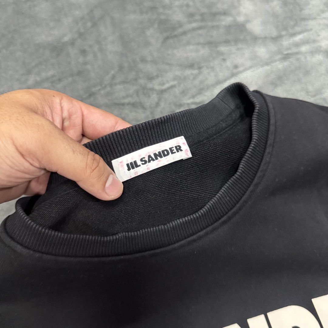 JIL SANDER LOGO LONG SLEEVE (Category: Luxury Apparel) located in Santa Maria. Submitted by rarefindslt (Listing ID 1461836554, Image 3). Description: JIL SANDER LONG SLEEVE (SWIPE LEFT FOR MORE DETAILS..) M on tag in solid black condition color rate! with tags for authenticity, front script logo, puff print! cuffs and collar still in good condition, can pass as new! no other issues.
