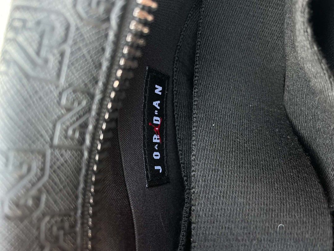 Jordan Black "23" Pattern Crossbody Bag (Category: Cross-body Bags) located in Cavite. Submitted by ara.thrifts (Listing ID 1461820026, Image 2). Description: - Authentic Jordan crossbody bag - Features an all-over "23" pattern - Silver Jumpman logo on the front - Secure zipper closure - Interior tag reads "Jordan" - Ideal for carrying everyday essentials.