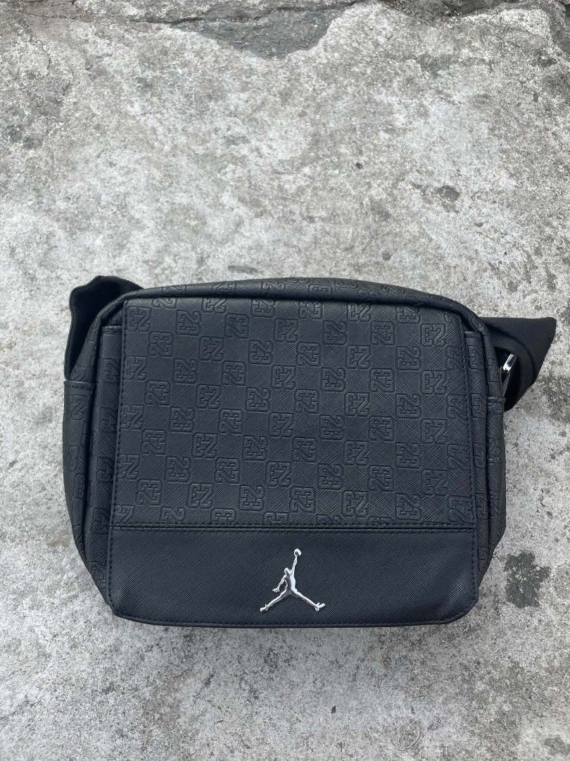 Jordan Black "23" Pattern Crossbody Bag (Category: Cross-body Bags) located in Cavite. Submitted by ara.thrifts (Listing ID 1461820026, Image 1). Description: - Authentic Jordan crossbody bag - Features an all-over "23" pattern - Silver Jumpman logo on the front - Secure zipper closure - Interior tag reads "Jordan" - Ideal for carrying everyday essentials.