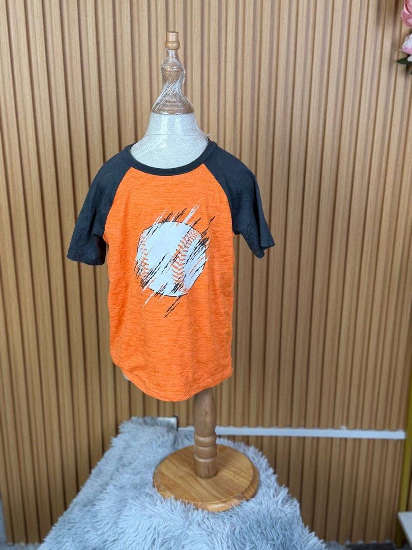 Jumping Beans Active Baseball T-shirt Size 5 Orange (Category: Tshirts & Polo Shirts ) located in Batangas. Submitted by ishaswonders (Listing ID 1461890676, Image 1). Description: - Vibrant orange t-shirt with a cool baseball graphic - Stylish dark grey raglan sleeves - Crafted from a comfortable recycled polyester and spandex blend - Designed for active kids, offering ease of wear - Ideal for everyday play and comfort.