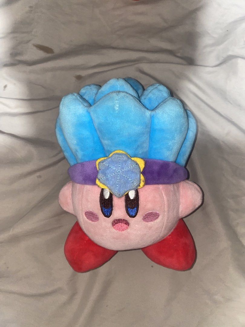 Kirby Plush Toy with Blue Flower Hat (Category: Plushies & Soft Toys) located in San Mateo. Submitted by fishermanbeanie (Listing ID 1461844693, Image 1). Description: - Adorable Kirby plush toy. - Features a cute blue flower-like hat with a purple band and yellow star detail. - Pink Kirby with distinctive red feet. - Made from soft, huggable material. - An ideal gift for any Kirby enthusiast. - Looking for a loving new home!.