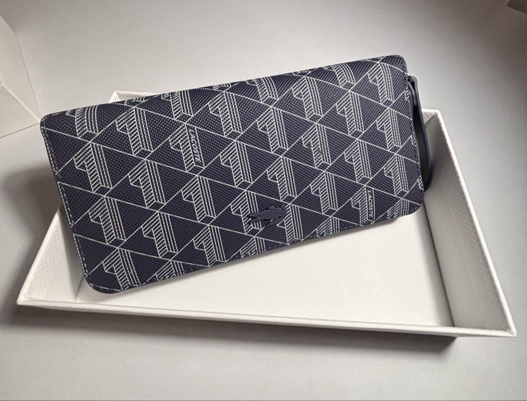 Lacoste Monogram Print Zip Around Wallet (Category: Wallets & Card holders) located in Rizal (Liwan). Submitted by mesco2768266 (Listing ID 1461953459, Image 2). Description: - Navy blue Lacoste zip-around wallet - All-over signature monogram print - Convenient wrist strap included - Ample card slots and compartments for organization - Comes in its original box.