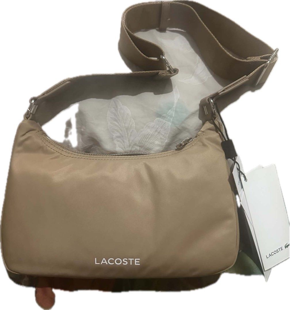 Lacoste Nylon Shoulder Bag (Category: Shoulder Bags) located in Manila. Submitted by eunite1025 (Listing ID 1461957694, Image 1). Description: - Authentic Tan/Beige Lacoste Shoulder Bag - Made of durable nylon material - Secure zip closure - Adjustable strap for comfortable wear - Brand new with original tags attached - Ideal for everyday use.