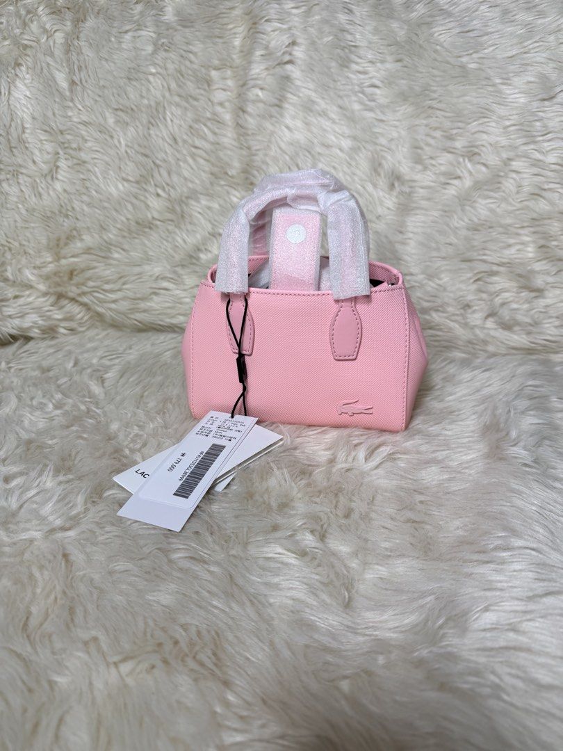Lacoste Pink Mini Tote Bag (Category: Tote Bags) located in Cebu City. Submitted by hazelcris (Listing ID 1461845834, Image 1). Description: - Cute pink mini tote bag from Lacoste - Signature crocodile logo embossed on the front - Handles still have protective plastic wrap - Brand new with tags attached - Lined interior with a small pocket - Ideal for carrying your daily essentials.