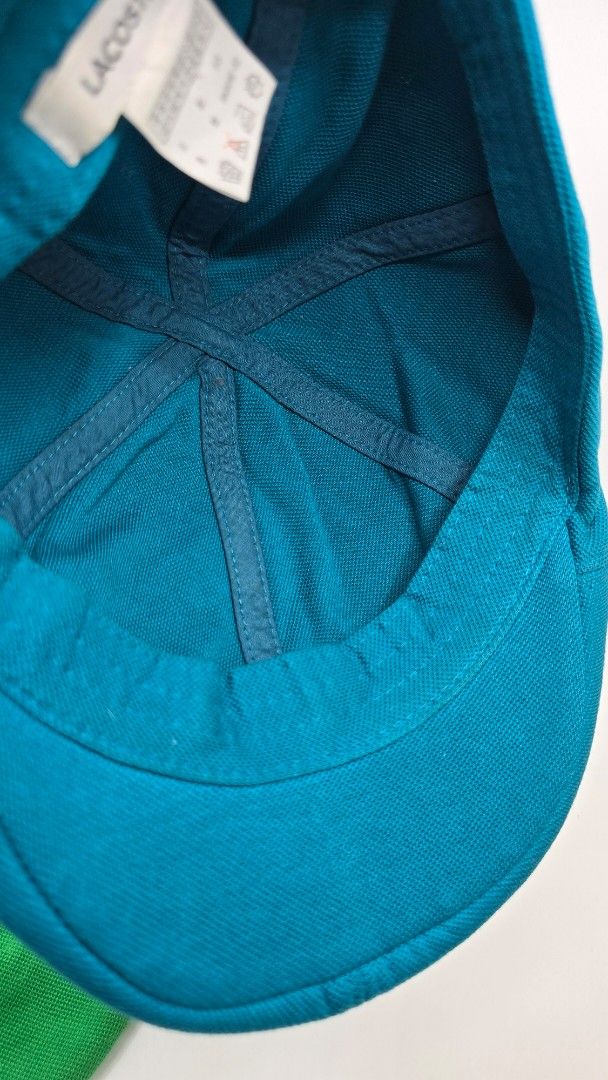 Lacoste Teal Cap (Category: Caps & Hats) located in Quezon City. Submitted by ShoesManila (Listing ID 1461983965, Image 3). Description: Lacoste flat cap Fit the most Condition: Excellent Color rate: 10/10 Complete tags Ready to use Ready to ship No COD Location: Diliman, QC - Lacoste teal cap - Textured material - Classic crocodile logo on the side - Standard baseball cap style - Ideal for sunny days and casual wear.