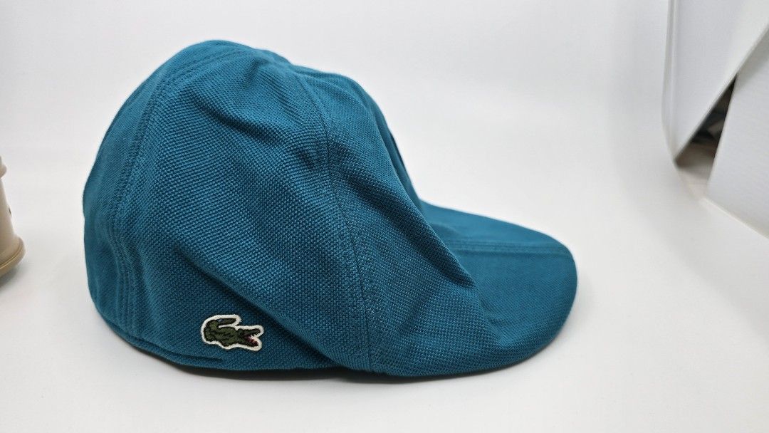 Lacoste Teal Cap (Category: Caps & Hats) located in Quezon City. Submitted by ShoesManila (Listing ID 1461983965, Image 1). Description: Lacoste flat cap Fit the most Condition: Excellent Color rate: 10/10 Complete tags Ready to use Ready to ship No COD Location: Diliman, QC - Lacoste teal cap - Textured material - Classic crocodile logo on the side - Standard baseball cap style - Ideal for sunny days and casual wear.