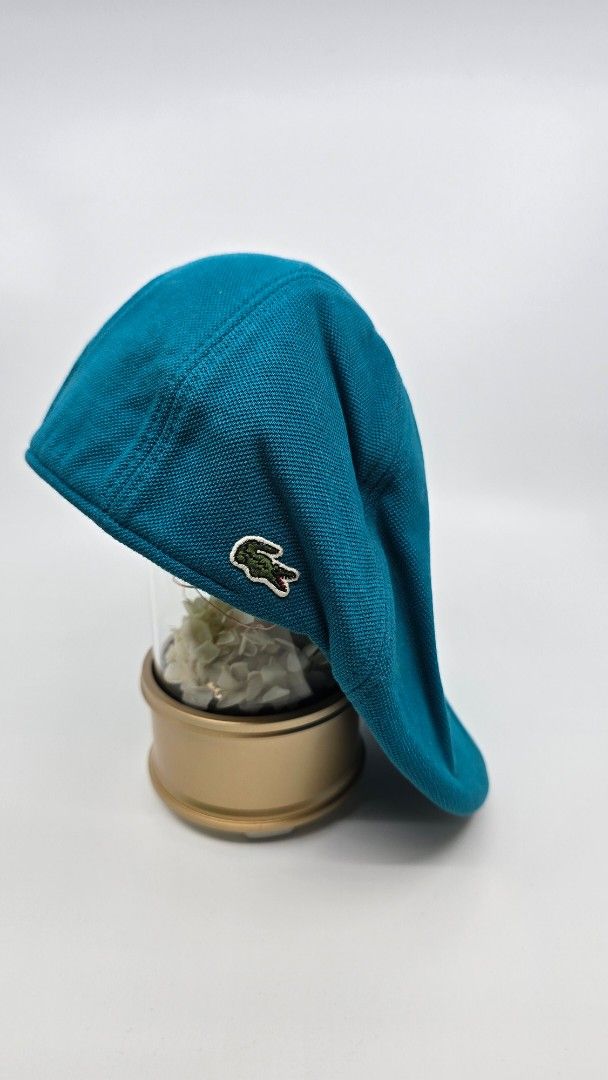Lacoste Teal Cap (Category: Caps & Hats) located in Quezon City. Submitted by ShoesManila (Listing ID 1461983965, Image 2). Description: Lacoste flat cap Fit the most Condition: Excellent Color rate: 10/10 Complete tags Ready to use Ready to ship No COD Location: Diliman, QC - Lacoste teal cap - Textured material - Classic crocodile logo on the side - Standard baseball cap style - Ideal for sunny days and casual wear.