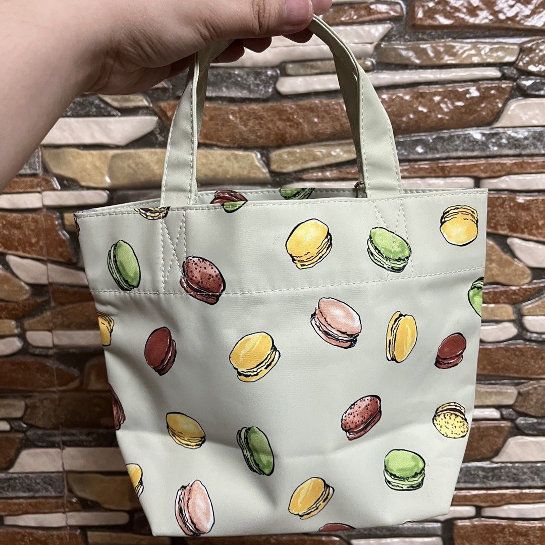 Ladurée Macaron Print Tote Bag (Category: Tote Bags) located in San Pedro. Submitted by rainyydayy (Listing ID 1461962362, Image 2). Description: - Adorable tote bag with a charming Ladurée macaron print. - Features a lovely light pastel green color. - Comes with a cute small charm attached to the handle. - Perfect size for carrying your daily essentials. - A must-have for Ladurée enthusiasts and lovers of cute accessories!.