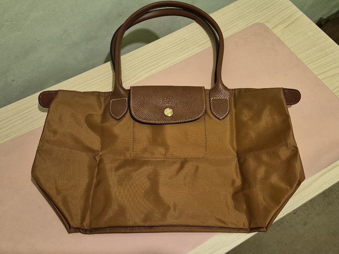 Longchamp Le Pliage Tote Bag - Brown (Category: Tote Bags) located in Quezon City. Submitted by gbabesy2.0 (Listing ID 1461803710, Image 1). Description: Longchamp Le Pliage Medium Long Handle Tote - Rich brown color (Conjac) - Durable nylon with leather accents - Gold-toned hardware - Zipper closure (YKK zipper with number '45') - Longchamp logo zipper pull and snap button - Medium size, perfect for everyday - Folds flat for easy storage - Clear