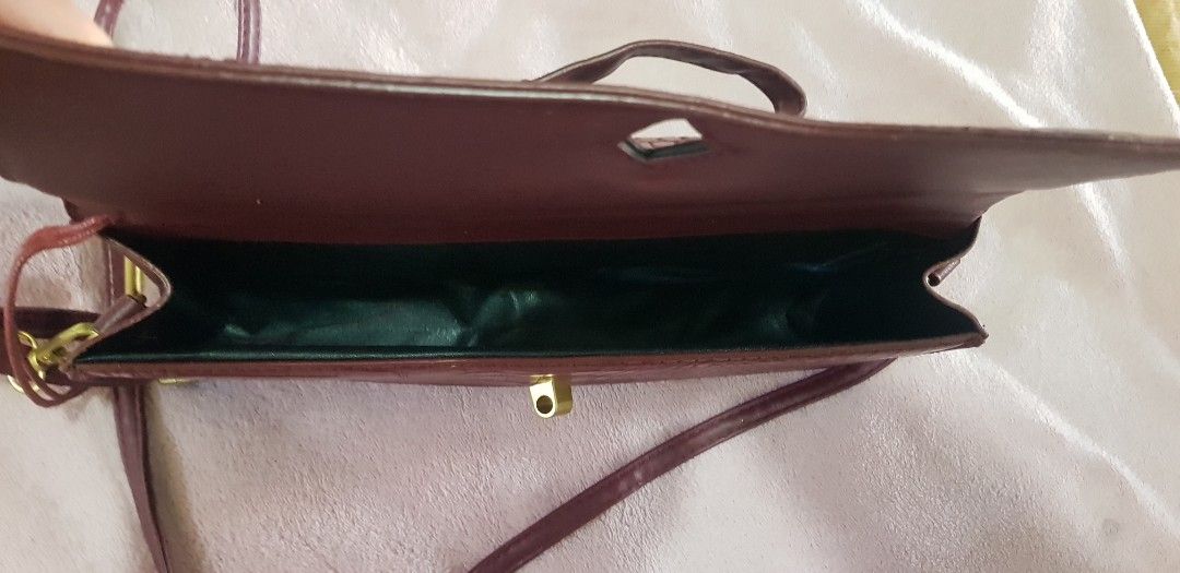 Maroon Crocodile Embossed Clutch Bag with Strap (Category: Clutches) located in Quezon City. Submitted by seventeenjeonghan (Listing ID 1461808098, Image 3). Description: - Elegant maroon clutch bag - Crocodile embossed texture - Convenient top handle - Detachable long strap for versatility - Stylish gold hardware on front closure - Lined with dark green material - Ideal for evening wear and special occasions.