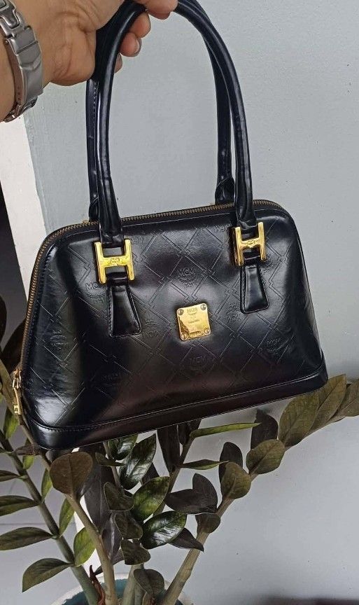 MCM Black Monogrammed Leather Dome Handbag (Category: Luxury Bags & Wallets) located in Manila. Submitted by boldfire_315559 (Listing ID 1461839335, Image 1). Description: - Classic black MCM dome handbag - Signature MCM monogram pattern embossed all over - Gold hardware details - Zipper closure - Interior MCM lining with a small zip pocket - Versatile for everyday or special occasions - A timeless MCM piece.