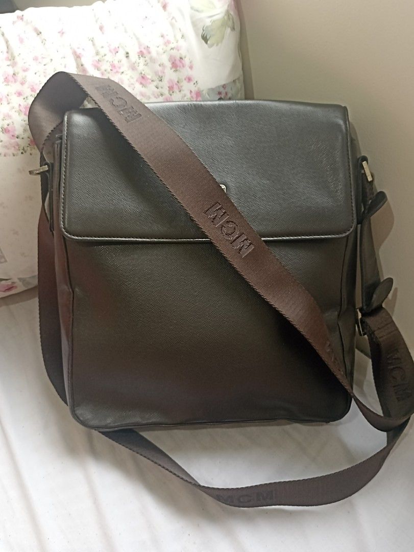 MCM München Leather Crossbody Bag (Category: Luxury Bags & Wallets) located in Quezon City. Submitted by racsprelovedselling (Listing ID 1461842142, Image 2). Description: - Authentic dark brown MCM crossbody bag - Made of genuine leather - Features iconic MCM logo plate - Adjustable strap with MCM branding - Secure flap closure with magnetic snaps - Spacious interior for essentials - Ideal for everyday use.