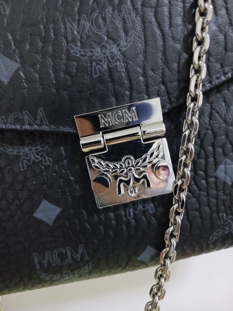 MCM Monogram Wallet on Chain Black (Category: Luxury Bags & Wallets) located in Paranaque City. Submitted by fermindebbs21 (Listing ID 1461911516, Image 2). Description: - Authentic MCM wallet on chain in black - Features iconic MCM monogram print - Elegant silver-tone hardware with MCM logo clasp - Detachable chain strap for versatile wear - Interior includes card slots and a secure zip pocket - Ideal for carrying essentials on nights out or dai