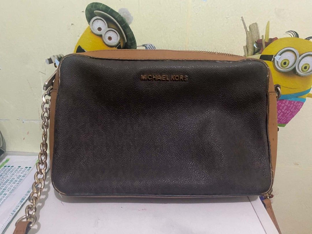 Michael Kors Brown Monogram Chain Crossbody Bag (Category: Luxury Bags & Wallets) located in Manila. Submitted by buywith_me (Listing ID 1461850146, Image 1). Description: - Authentic Michael Kors crossbody bag - Classic brown and tan monogram print - Elegant gold chain strap - Secure zipper closure - Ideal for everyday use - Shows some signs of wear on edges and strap.