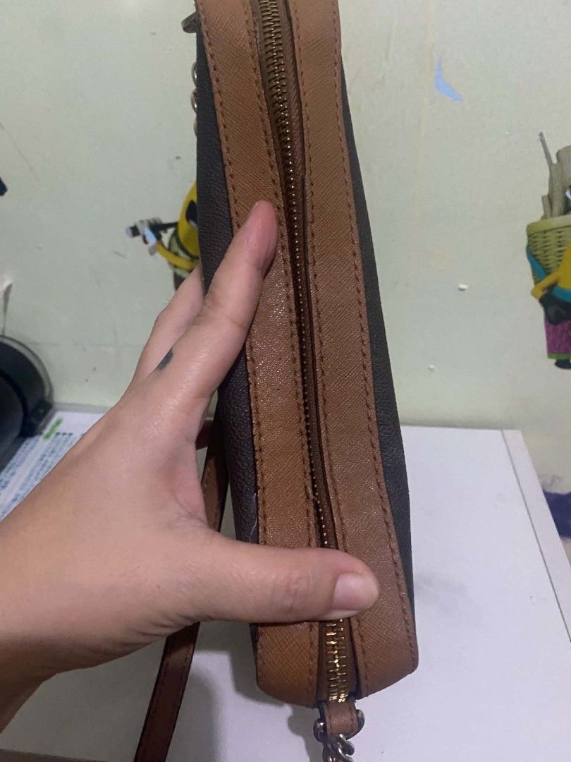 Michael Kors Brown Monogram Chain Crossbody Bag (Category: Luxury Bags & Wallets) located in Manila. Submitted by buywith_me (Listing ID 1461850146, Image 2). Description: - Authentic Michael Kors crossbody bag - Classic brown and tan monogram print - Elegant gold chain strap - Secure zipper closure - Ideal for everyday use - Shows some signs of wear on edges and strap.