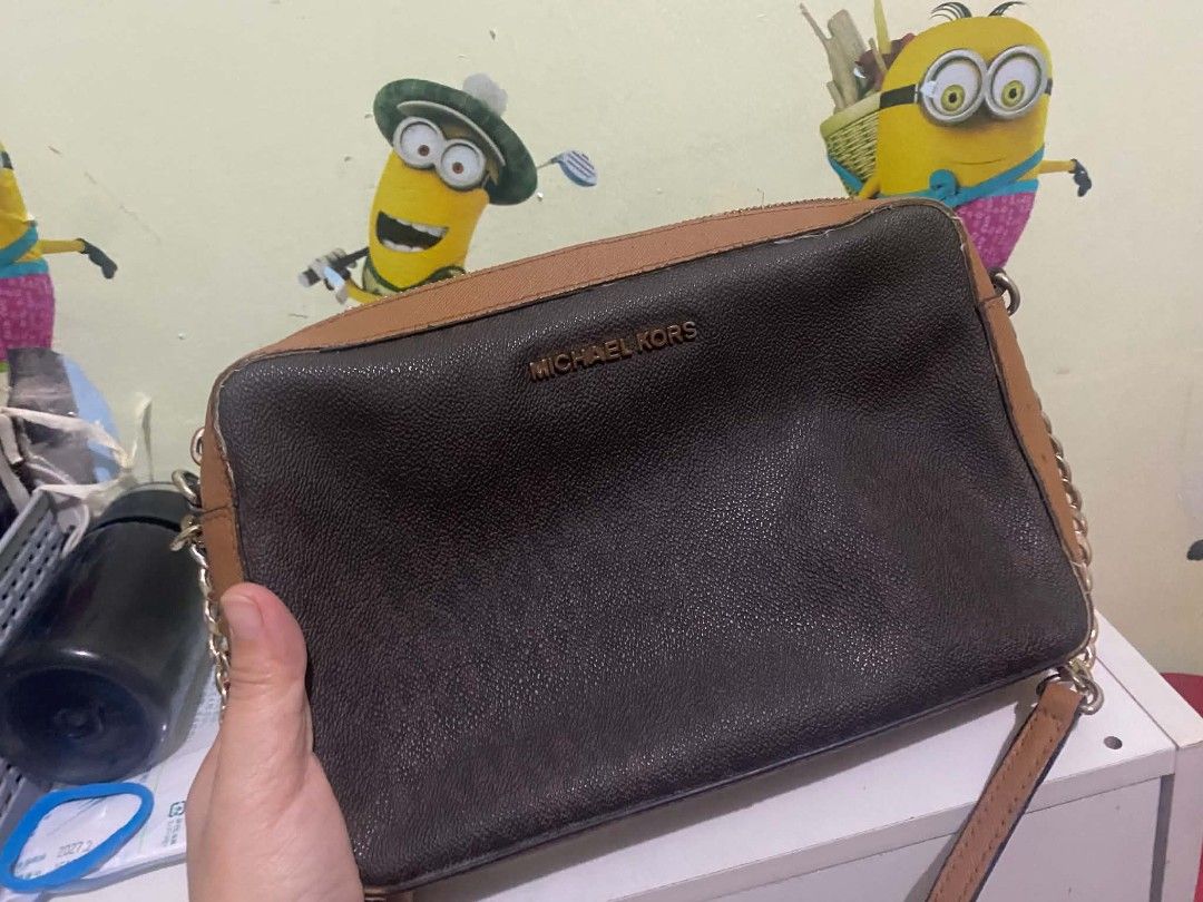 Michael Kors Brown Monogram Chain Crossbody Bag (Category: Luxury Bags & Wallets) located in Manila. Submitted by buywith_me (Listing ID 1461850146, Image 3). Description: - Authentic Michael Kors crossbody bag - Classic brown and tan monogram print - Elegant gold chain strap - Secure zipper closure - Ideal for everyday use - Shows some signs of wear on edges and strap.