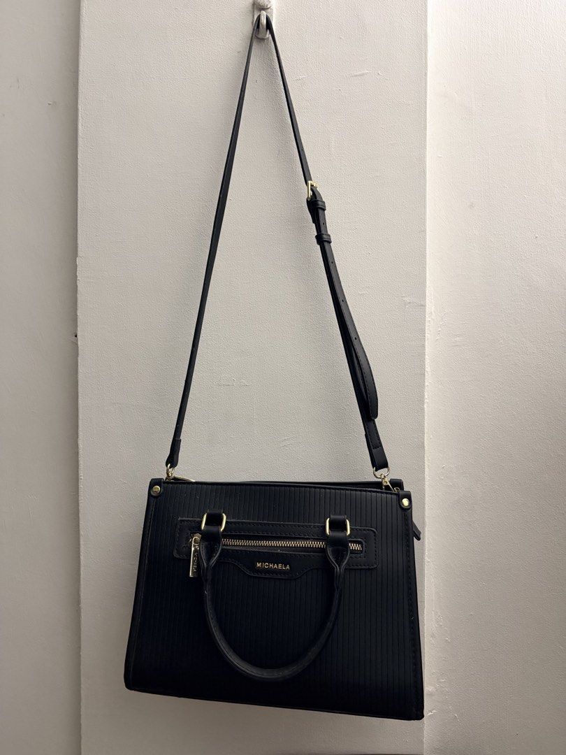 MICHAELA Black Textured Handbag with Shoulder Strap (Category: Shoulder Bags) located in Manila. Submitted by finderskeepersmnl_092026 (Listing ID 1461957845, Image 2). Description: - Stylish black Michaela handbag - Textured exterior with elegant gold hardware - Comfortable top handles - Includes a detachable shoulder strap for versatility - Convenient zippered pocket on the front - Spotless and clean interior - Ideal for everyday wear and erran