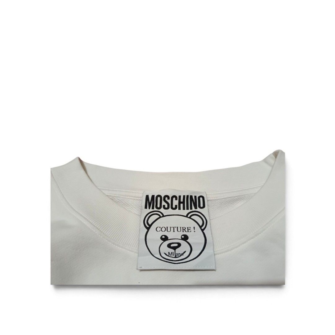 Moschino Couture Teddy Bear Sweatshirt (Category: Coats, Jackets and Outerwear) located in Manila. Submitted by southstreethub.ph (Listing ID 1461873242, Image 3). Description: - Authentic White Moschino Couture Sweatshirt - Condition: Like new Condition - Dimention: 18 Width 21 Lenght - Features iconic Moschino teddy bear graphic - 'Moschino Couture!' text detail - Made in Portugal - Ideal for stylish casual wear.