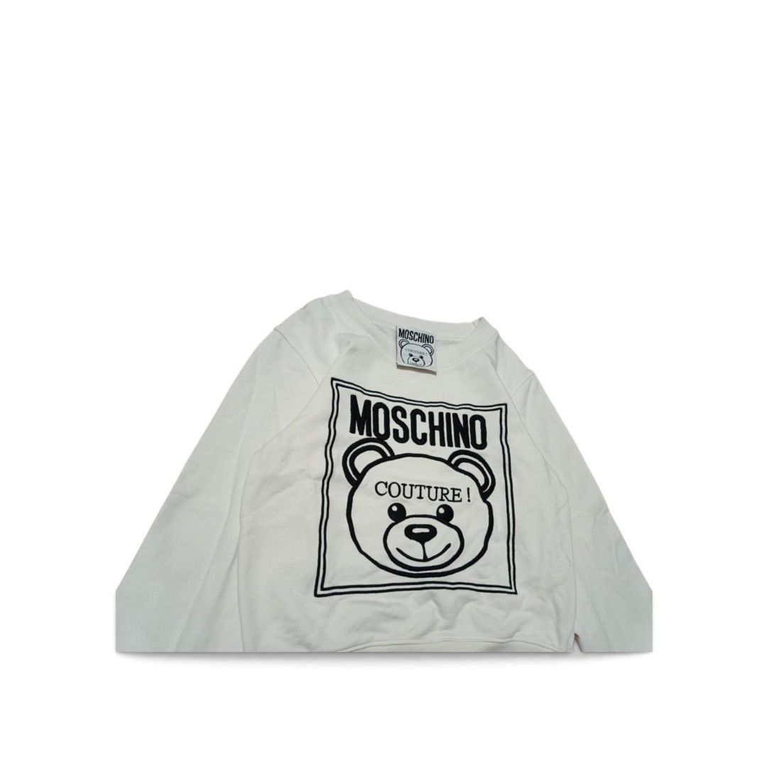 Moschino Couture Teddy Bear Sweatshirt (Category: Coats, Jackets and Outerwear) located in Manila. Submitted by southstreethub.ph (Listing ID 1461873242, Image 2). Description: - Authentic White Moschino Couture Sweatshirt - Condition: Like new Condition - Dimention: 18 Width 21 Lenght - Features iconic Moschino teddy bear graphic - 'Moschino Couture!' text detail - Made in Portugal - Ideal for stylish casual wear.