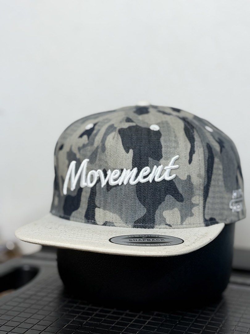 Movement Camo Snapback Hat (Category: Caps & Hats) located in Manila. Submitted by bunsmayo31 (Listing ID 1461992662, Image 2). Description: - Camo print snapback hat - 'Movement' embroidered on the front - Light-colored brim - Adjustable strap at the back - 'HYPHEN' detail on the side - Ideal for casual wear.