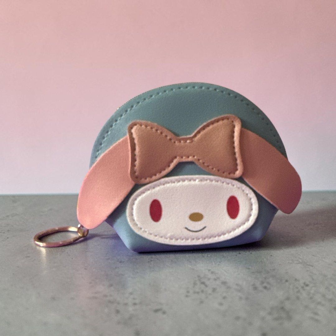 My Melody Coin Purse Mini (Category: Purses & Pouches) located in Quezon City. Submitted by ghessie (Listing ID 1461866993, Image 2). Description: ₱100 each - Adorable My Melody coin purse featuring her iconic face, pink bow, and long ears. - Includes a convenient keychain ring for easy attachment. - Perfect for storing coins, keys, or other small essentials. - Available in a variety of colors: pink, light pink, black, grey, teal, and blue..