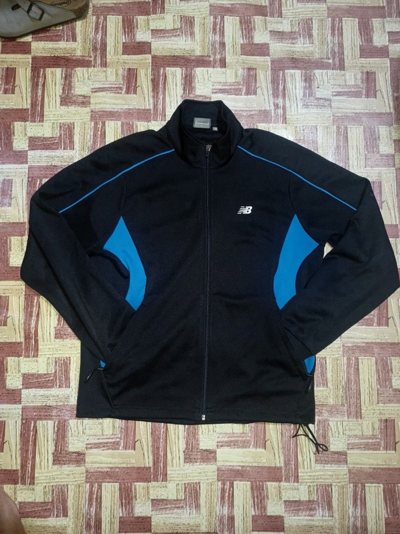New Balance Black Blue Track Jacket (Category: Coats, Jackets and Outerwear) located in Pasig City. Submitted by atmclick (Listing ID 1461979460, Image 1). Description: - Brand: New Balance - Color: Black with blue accents on sides and sleeves - Closure: Full zip - Features: Pockets - Size: 100 - dimes 21x26 - Ideal for: Workouts or casual wear - issue need washed.