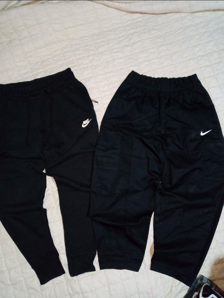 Nike Black Track Pants and Joggers (Category: Joggers) located in Allen. Submitted by milyonaryung_gipit (Listing ID 1461853150, Image 1). Description: - Two pairs of black Nike pants - Pair 1: Loose fit track pant style - Pair 2: Tapered leg jogger with cuffed ankles Small size - Both feature the iconic Nike logo - Versatile for sports or everyday casual wear.