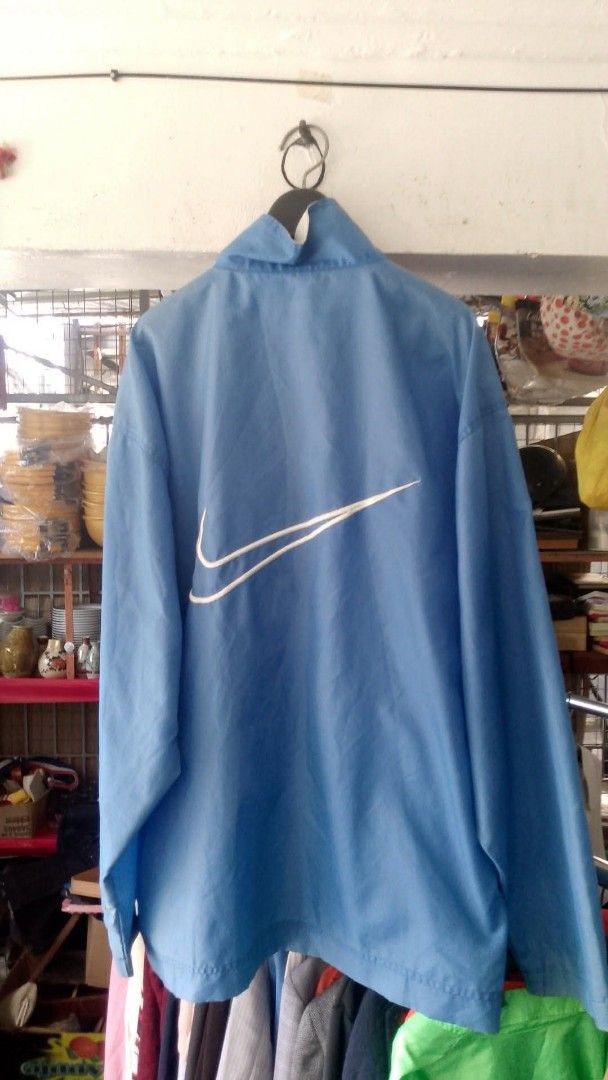 Nike Blue Pullover Windbreaker Jacket (Category: Coats, Jackets and Outerwear) located in Manila. Submitted by romeoamoro00044 (Listing ID 1461945903, Image 2). Description: - Light blue Nike windbreaker jacket - Quarter zip pullover style - Large Nike swoosh logo on the back - Two front zip pockets - Made of 100% nylon - Ideal for casual wear or sports activities.
