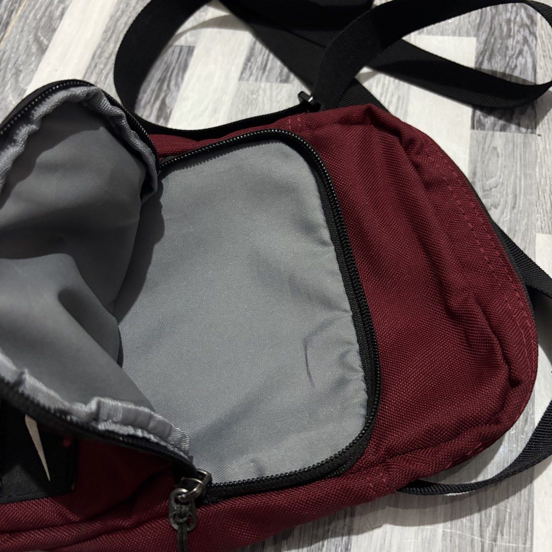 Nike Maroon Crossbody Bag (Category: Cross-body Bags) located in Banga. Submitted by akosiloco (Listing ID 1461920263, Image 3). Description: - Stylish maroon Nike crossbody bag - Convenient front zip pocket - Spacious main compartment - Handy back slip pocket (fits your phone!) - Adjustable strap for a comfortable fit - Durable 100% polyester material - Ideal for everyday errands or your next adventure!.