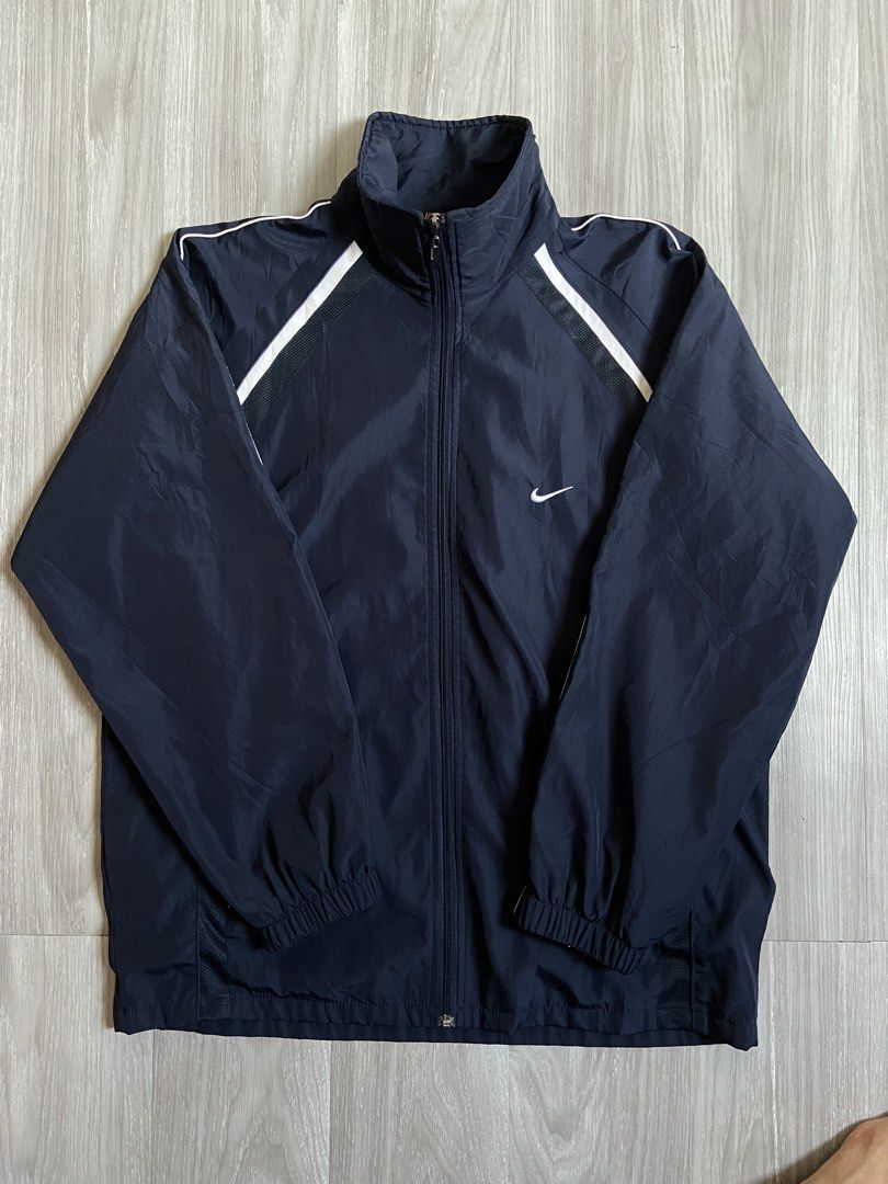 Nike Navy Blue Track Jacket with White Stripes (Category: Coats, Jackets and Outerwear) located in Cavite. Submitted by hail1530 (Listing ID 1461876963, Image 1). Description: - Classic Nike track jacket - Navy blue with white stripe detailing on shoulders and sleeves - Full zip closure - Stand-up collar - Elasticated cuffs and hem - Ideal for casual wear or light workouts.