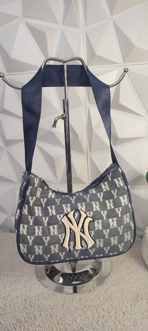 MLB Yankees Denim Shoulder Bag (Category: Shoulder Bags) located in Pasig City. Submitted by xcess_baggage (Listing ID 1461825010, Image 1). Description: - Stylish denim shoulder bag featuring an all-over NY Yankees logo print. - Prominent embroidered NY Yankees logo patch on the front. - Durable navy blue shoulder strap. - Secure zipper closure. - A must-have accessory for any New York Yankees fan..