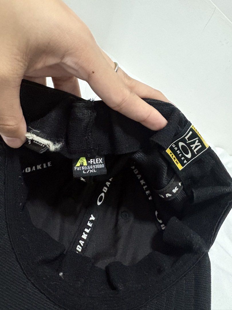 Oakley Black Metal Eclipse Cap (Category: Caps & Hats) located in Manila. Submitted by weararchive.mnl (Listing ID 1461877851, Image 3). Description: Oakley Black Metal Ellipse Cap 🧢 FIXED PRICE Preloved, good condition 🖤 • Authentic Oakley stretch-fit design • Raised metallic silver Ellipse logo on front • Oakley A-Flex fitted stretch band • Size: L/XL • Clean black colorway, versatile streetwear look.
