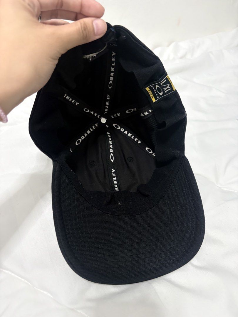 Oakley Black Metal Eclipse Cap (Category: Caps & Hats) located in Manila. Submitted by weararchive.mnl (Listing ID 1461877851, Image 2). Description: Oakley Black Metal Ellipse Cap 🧢 FIXED PRICE Preloved, good condition 🖤 • Authentic Oakley stretch-fit design • Raised metallic silver Ellipse logo on front • Oakley A-Flex fitted stretch band • Size: L/XL • Clean black colorway, versatile streetwear look.