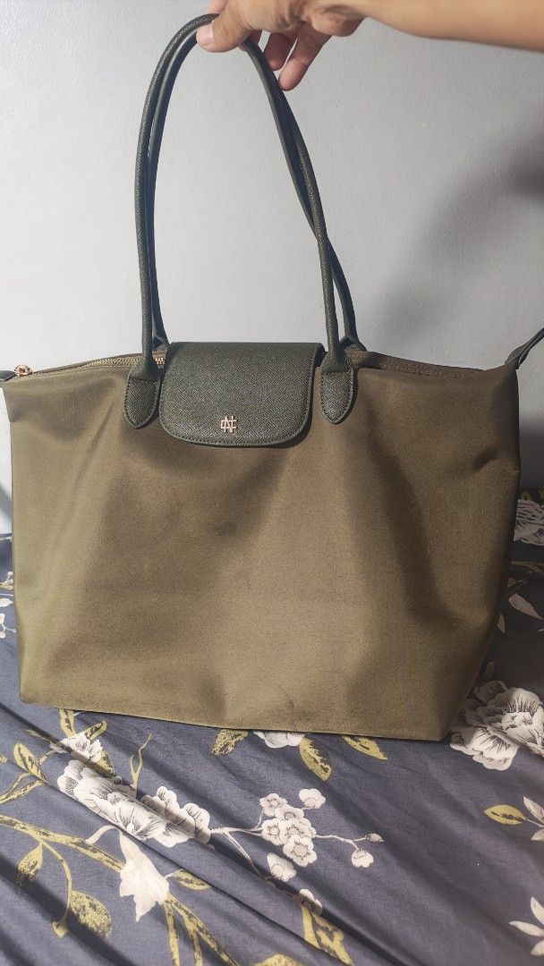Olive Green Nylon Tote Bag Nylon (Category: Tote Bags) located in Manila. Submitted by chubbychic553 (Listing ID 1462029273, Image 2). Description: PRELOVED CHRISTY NG olive green tote bag LARGE SIZE nylon material with faux leather trim and handles Secure top zipper closure Convenient front flap pocket with subtle logo PHP 1200 mode of payment gcash BDO paymaya location Tayuman Manila shipping via LBC, J&T or lalamove no cod no cop can do video 