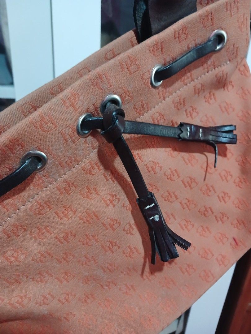 Orange Monogram Drawstring Bucket Bag with Leather Accents (Category: Luxury Bags & Wallets) located in Marikina City. Submitted by laila15 (Listing ID 1461955267, Image 1). Description: - Chic orange bucket bag with repeating monogram pattern - Features stylish leather drawstrings and comfortable handles - Multiple interior pockets for excellent organization - Secure magnetic snap closure - Ideal for everyday errands or your next getaway.