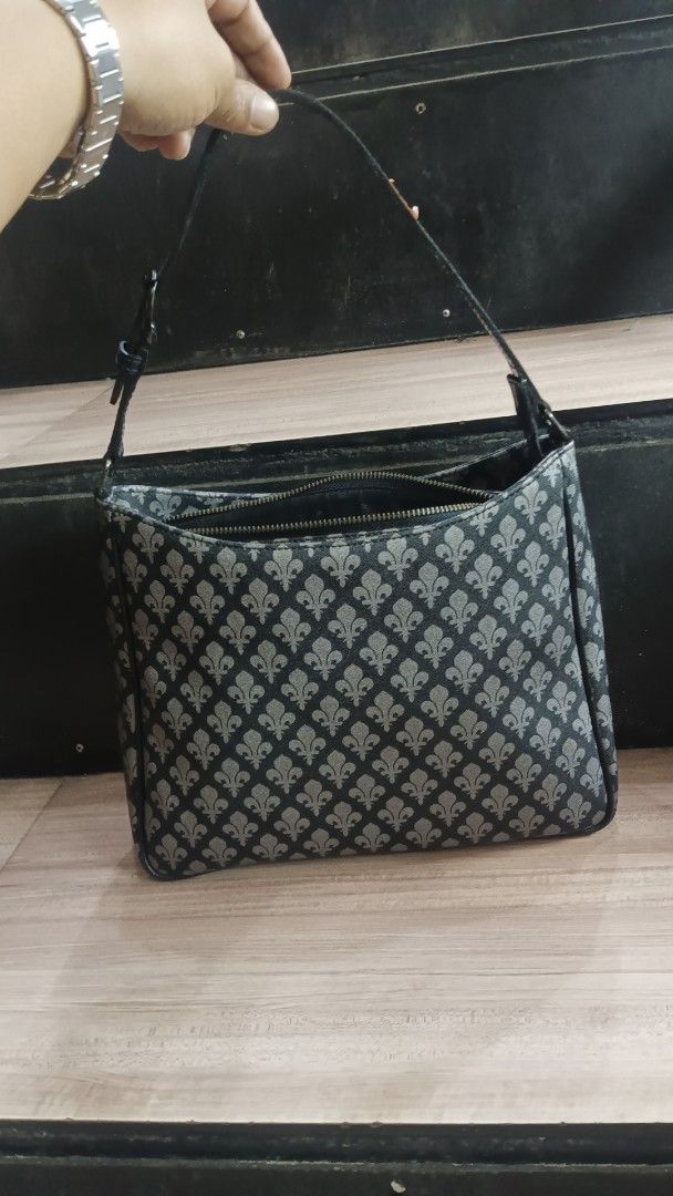 Patrick Cox London Shoulder Bag Fleur de Lis Pattern (Category: Shoulder Bags) located in Alaminos. Submitted by andreid12 (Listing ID 1461892409, Image 3). Description: - Stylish black shoulder bag with an all-over grey fleur de lis pattern. - Secure zipper closure for your belongings. - Interior features a "PATRICK COX LONDON" tag. - Adjustable strap with buckle for a comfortable fit. - Ideal size for carrying everyday essentials. - Clean and w