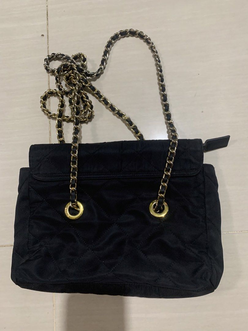 Prada Quilted Nylon Chain Shoulder Bag (Category: Luxury Bags & Wallets) located in Liloan. Submitted by jinalyns (Listing ID 1461892029, Image 2). Description: - Prada bag in black quilted nylon. - Elegant gold chain strap. - Secure flap closure with magnetic snap. - Interior zippered pocket for essentials. - Classic Prada logo detail on the front. - Versatile for everyday wear or evening events..